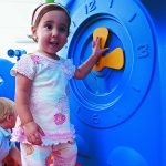 discovery center toddler play systems girl playing with the clock panel