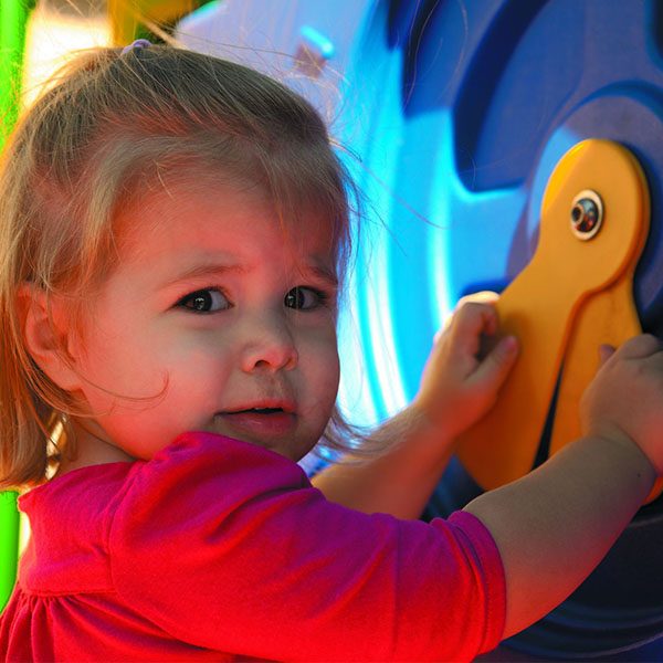 discovery center toddler play systems little girl playing with the clock panel